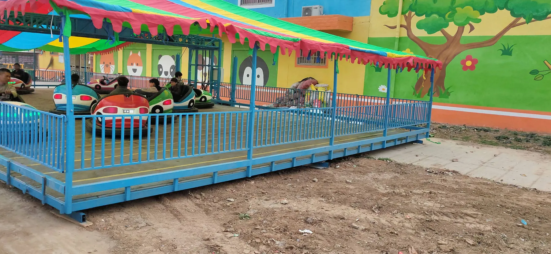 Children riding bumper cars at a mobile rink deployed at a local site