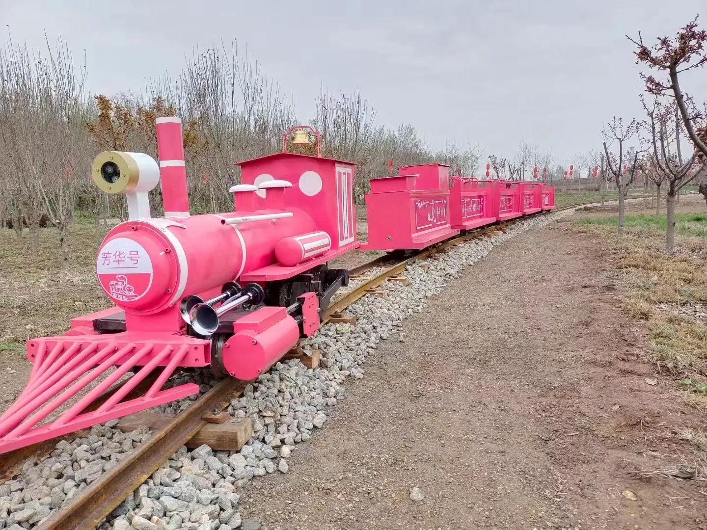 Trackless vs Track Train: Specs, Costs & How to Choose Pink themed track sightseeing train named Fanghua running on a ballast-laid 300 mm gauge railway